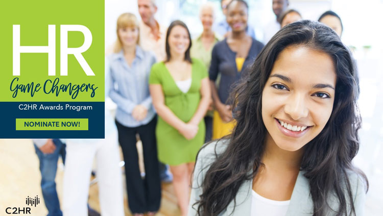 A colorful, continuous wall of dozens of digital displays viewed from a distant perspective, with bright, multi-colored reflections in the ceiling and floor
