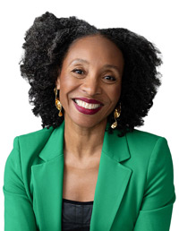 photo of the Natalie Nixon, seated at a table with hands clasped