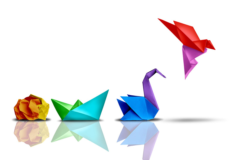 Paper origami creations, which are (left to right) orange and yellow crumpled paper, blue and green boat, blue and violet swan, to violet and red flying bird